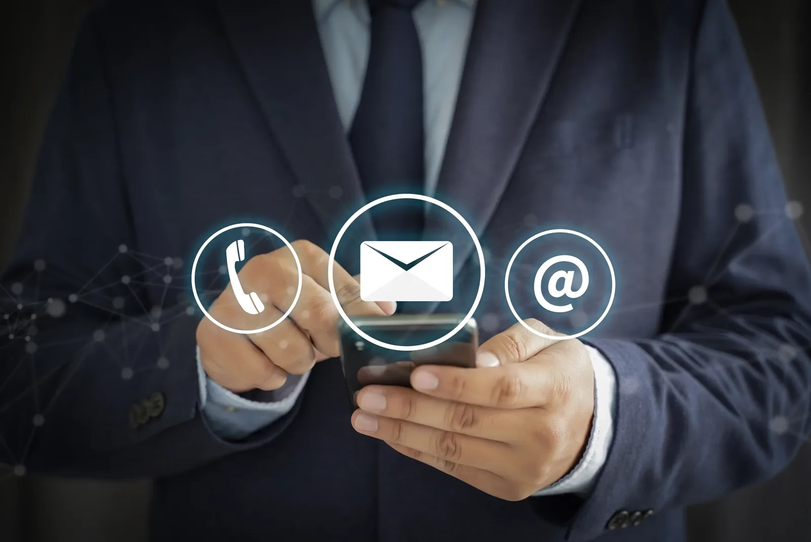 A person holding a smartphone with phone, envelope and at-symbol icons, representing direct contact with the practice.